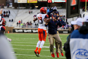 Andre Cisco celebrates with Syracuse coaches after intercepting his seventh pass of the season on Saturday.