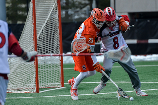Mariano tries to fight off the Red Storm's goalie Daniel Costa to scoop up a ground ball.