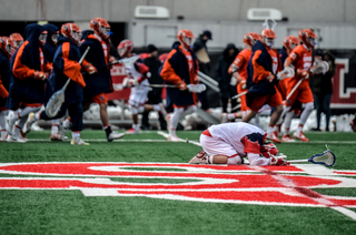 SJU's TJ Marron stays in disappointment as Syracuse celebrates the win. 